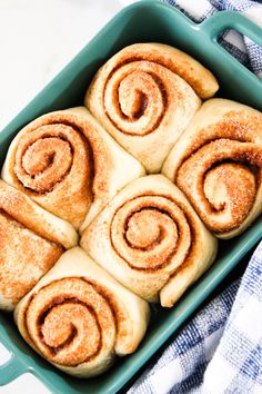 several cinnamon rolls in a green baking dish