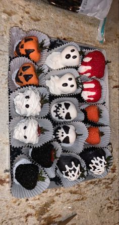 halloween cupcakes with white frosting and black icing are arranged on a tray