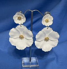 "This is a really pretty pair of white floral flower earrings.  The small flower at the top has the post for pierced ears.  The larger flower dangles from the smaller.  Each blossom has a gold center.  The length is 2 1/2\" and the width, 1 3/4\".    We are not sure what they are made of but they have the feel of soft leather.  They are in very good condition and are just perfect for the bride or summer occasion." White Dangle Flower Earrings For Spring, Elegant White Flower Earrings, Spring Wedding Dangle Flower Earrings, White Flower Earrings For Spring Wedding, White Dangle Jewelry For Spring, Spring White Jewelry With Matching Earrings, White Wedding Jewelry For Spring, Spring Wedding White Jewelry, White Jewelry With Matching Earrings For Spring