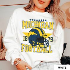 Perfect sweatshirt for Michigan football fans this season! Ideal for any situation, a unisex heavy blend crewneck sweatshirt is pure comfort. These garments are made from polyester and cotton. This combination helps designs come out looking fresh and beautiful. The collar is ribbed knit, so it retains its shape even after washing. There are no itchy side seams on these sweaters.  .: 50% cotton, 50% polyester .: Medium-heavy fabric (8.0 oz/yd² (271.25 g/m .: Loose fit .: Sewn-in label .: Runs tru Fleece Graphic Print Sweatshirt For Fans, Fan Apparel Fleece Sweatshirt With Graphic Print, Fleece Fan Apparel Sweatshirt, White Sweatshirt Fan Gear For Fall, Fan Gear Graphic Print Hoodie With Crew Neck, White Fan Gear Sweatshirt For Fall, White Sweatshirt For Fall Fan Gear, White Fan Apparel Sweatshirt, Team-colored Sweatshirt With Team Logo For Fans