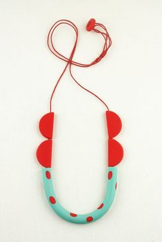 a red and blue necklace with two hearts on the front, hanging from a string