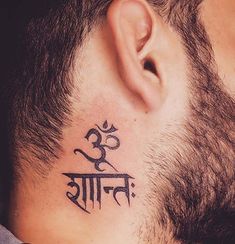 a man with a tattoo on his neck has the word om shant written in it