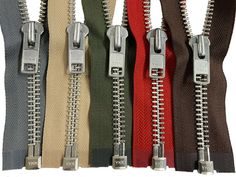 six different colors of zippers with one open and the other closed, all lined up