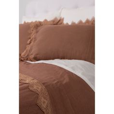 a bed with brown and white sheets and pillows