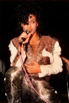 michael jackson performing on stage with microphone in his hand and wearing an elaborate outfit, circa 1970