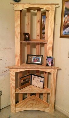 a wooden corner shelf with pictures on it