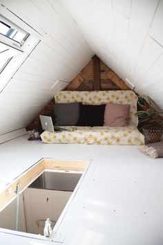 an attic bedroom with a couch and window