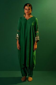 Emerald green placement sequin mirror hand embroidered kurta with batwing sleeves. Paired with a slim fit pant.
Components: 2
Pattern: Hand Embroidery
Type Of Work: Sequins
Neckline: V Neck
Sleeve Type: Full Sleeves
Fabric: Satin
Color: Green
Other Details: 
Note: All the jewellery worn by the model is not for sale
Occasion: Sangeet - Aza Fashions Green Dabka Kaftan For Party, Embellished Green Palazzo Set For Eid, Green Kaftan With Mirror Work For Navratri, Green Sequined Salwar Kameez For Diwali, Green Anarkali Salwar Kameez With Sequins, Festive Green Salwar Kameez With Sequins, Green Sequined Salwar Kameez For Eid, Party Green Salwar Kameez With Sequins, Designer Green Kaftan With Mirror Work