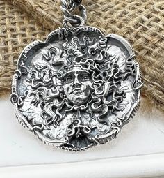 "Hand made Design by Sal Knight The Medusa in sterling silver light antique finish with ruby eyes 30 millimeters wide, 1 1/4\" inches Double linked sterling silver chain" Silver Hand Forged Medallion Jewelry, Artisan Jewelry Pendant With Antique Finish, Spiritual Jewelry With Antique Finish, Artisan Pendant Jewelry With Antique Finish, Antique Silver Sterling Silver Jewelry, Antique Silver Sterling Silver Jewelry With Antique Finish, Antique Silver Oxidized Round Jewelry, Sterling Silver Jewelry With Antique Finish In Antique Silver, Antique Finish Sterling Silver Jewelry In Antique Silver