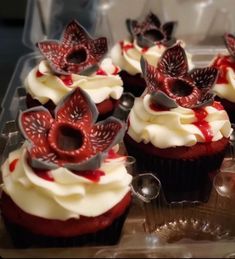 cupcakes with white frosting and red decorations