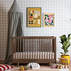 a baby crib in the corner of a room with two paintings on the wall