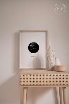 a white vase sitting on top of a wooden table next to a black and white photo