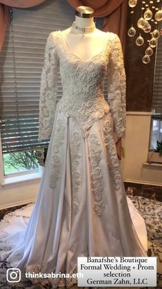 a wedding dress on display in front of a window