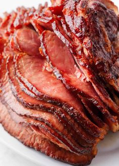 sliced meat on a white plate sitting on a table