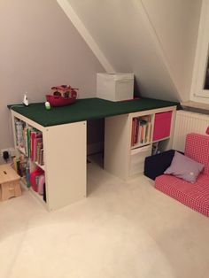 a room with a bed, desk and bookshelf in it's corner