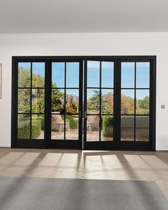 an empty room with black doors and windows