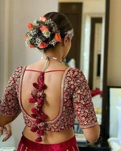 the back of a woman's dress with flowers in her hair