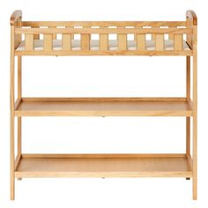 a wooden baby crib with two shelves on each side and a white mattress in the middle