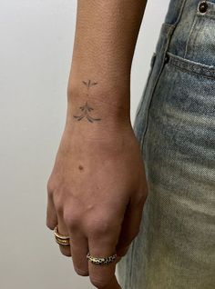 a person with a tattoo on their left arm and wrist, holding onto another hand