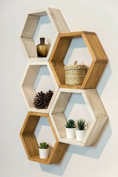 three wooden hexagonal shelves with plants on each shelf and one potted plant in the middle