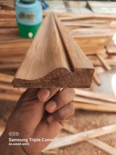 a hand holding up a piece of wood