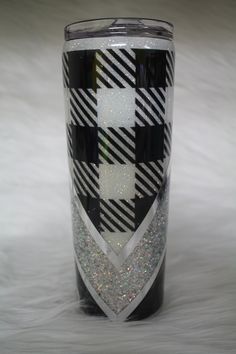 a black and white checkerboard tumbler with glitters on it's side