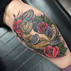 an animal tattoo on the arm with roses