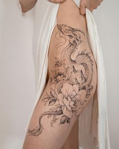 a woman with a dragon tattoo on her thigh