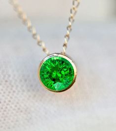 Genuine earth mined AA tsavorite garnet set in solid 14k gold in a slide pendant. The pendant moves on the chain. A simple classic style that you can never go wrong with.  Stone Size : 4mm Necklace Length : see options Metal : 14k Gold Gemstone : 0.3 cts (4mm stone)  Earth Mined AA Tsavorite Garnet or 0.6 cts (5mm stone) Packaging : All products purchased from us come in a gift box. If you need to include a message, kindly leave us a note when purchasing.  Care Recommendations:  When not in use, Green Gemstone Birthstone Necklace In 14k Gold, Gold Tsavorite Emerald Necklace As Gift, Green Pendant Birthstone Necklace In 14k Gold, Green Birthstone Pendant Necklace In 14k Gold, Tsavorite Emerald Necklace In Yellow Gold, Green 14k Gold Pendant Birthstone Necklace, 14k Gold Green Birthstone Pendant Necklace, Formal Green Birthstone Necklace In 14k Gold, Yellow Gold Emerald Necklace With Tsavorite