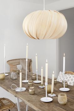 a wooden table topped with lots of white candles