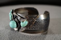 I am offering this fabulous vintage silver tone bracelet. This piece is truly gorgeous, and it has the following features: * beautiful vintage bangle * faux turquoise * cuff design * floral design * glass stone * 3 inches in length This is a fantastic and classic piece. There is tons of sparkle and shine with this piece. It will beautifully complement your upcoming fashion season. Buyer pays all shipping and handling. Vintage Hand Cast Cuff Bangle Bracelet, Vintage Hand Cast Bangle Cuff Bracelet, Vintage Hand Cast Cuff Bangle, Handmade Turquoise Vintage Cuff Bracelet, Vintage Nickel-free Cuff Bracelet For Weddings, Vintage Nickel-free Turquoise Cuff Bracelet, Nickel-free Vintage Cuff Bracelet For Wedding, Vintage Hand Cast Cuff Bracelet As Gift, Antique Turquoise Cuff Bracelet Gift