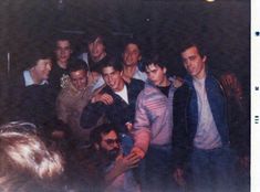 a group of men standing next to each other in front of a crowd at a party