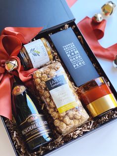 an open gift box filled with wine and snacks