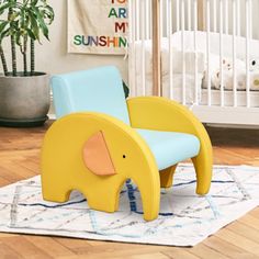 an elephant shaped chair sitting on top of a rug in front of a crib