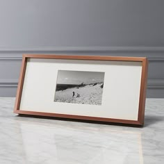 a white marble counter top with a wooden frame holding a black and white photo on it