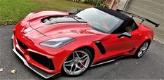 a red sports car parked in front of a garage