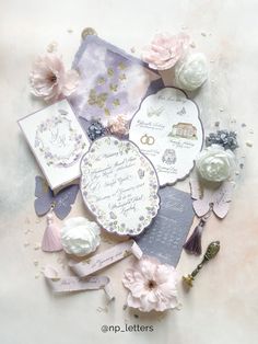 the wedding stationery is laid out on top of each other with flowers and ribbons