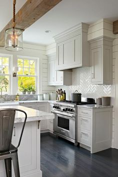 a kitchen with white cabinets and an island in front of the stove top oven is shown