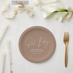 a plate with a name on it sitting next to some forks and napkins, along with other items