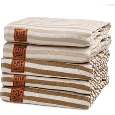 four folded beige and white striped towels stacked on top of each other with brown labels