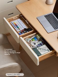 a laptop computer sitting on top of a wooden desk next to a drawer filled with magazines