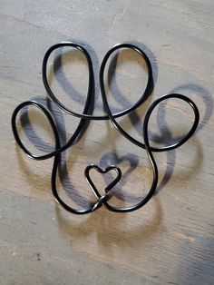 four black metal scissors shaped like a heart on a wooden table with the shape of a cat's head