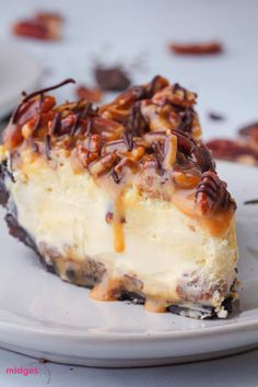 a white plate topped with a piece of cheesecake covered in pecans and caramel