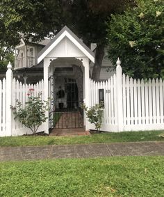 a white picket fence surrounds a small house