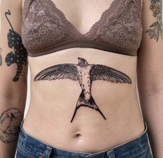 a woman's stomach with a tattoo of a hummingbird on it