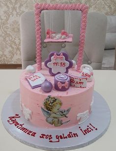 a pink birthday cake with decorations on it