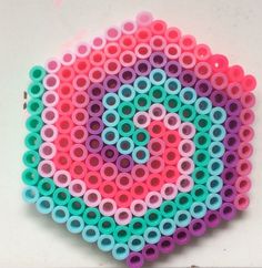 a colorful object made out of plastic tubes on a white surface with the letter q in the middle