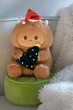 a teddy bear sitting on top of a green pillow