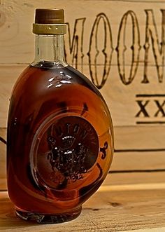 a bottle of liquor sitting on top of a wooden table