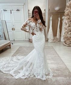 a woman is taking a selfie in her wedding dress while looking into the mirror